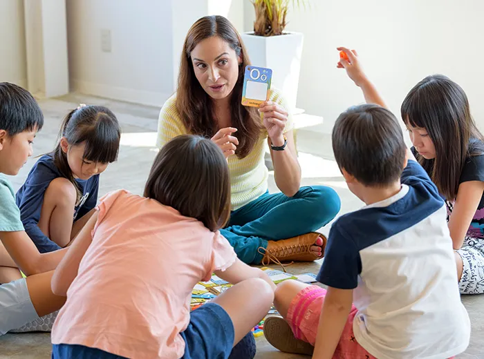 円になって座り、英語を学ぶ児童